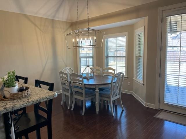 dining room with dark wood-style floors, baseboards, and a chandelier