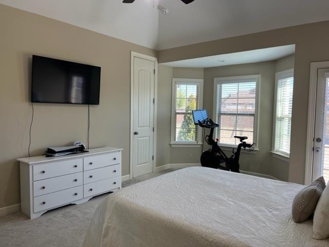 bedroom featuring a ceiling fan, lofted ceiling, light colored carpet, and baseboards