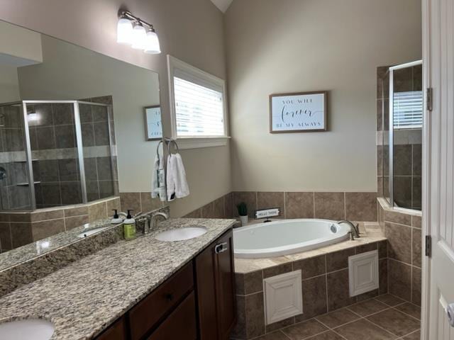 full bath with double vanity, a sink, tile patterned flooring, a shower stall, and a bath