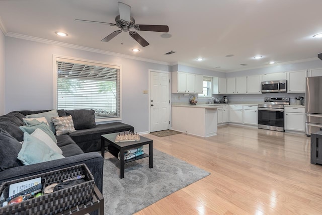 living room with ornamental molding, light wood-type flooring, and recessed lighting