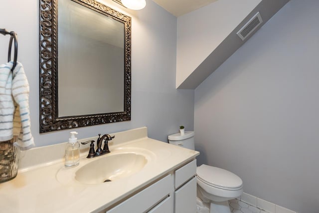 half bath featuring toilet, tile patterned floors, visible vents, and vanity