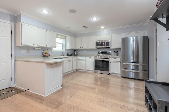 kitchen featuring appliances with stainless steel finishes, light wood-type flooring, white cabinets, and light countertops