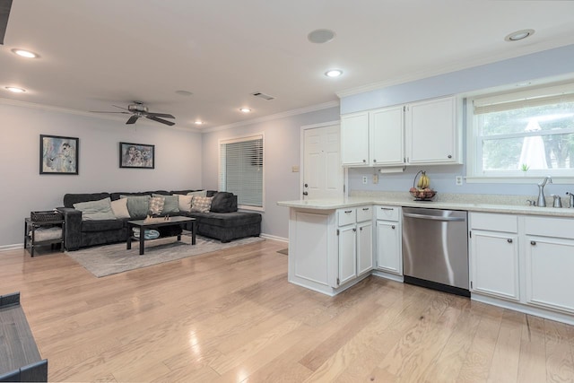 kitchen featuring a sink, visible vents, light countertops, dishwasher, and crown molding