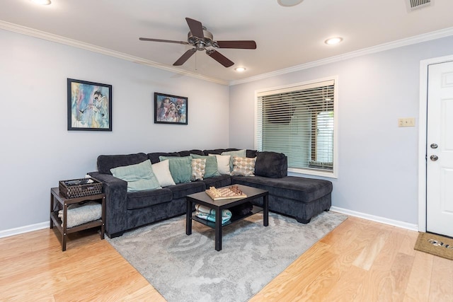 living room with crown molding, baseboards, and wood finished floors