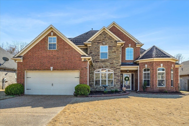 traditional home with driveway, stone siding, a garage, and brick siding