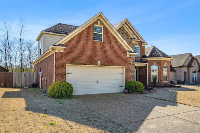 traditional home with driveway, brick siding, and fence