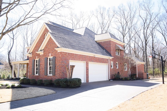 view of side of property with concrete driveway, brick siding, an attached garage, and a shingled roof