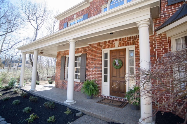 property entrance featuring covered porch and brick siding