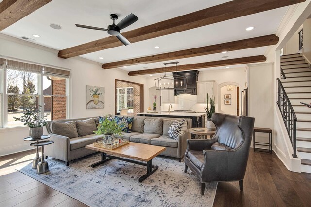 living room featuring arched walkways, dark wood-style flooring, visible vents, and stairs