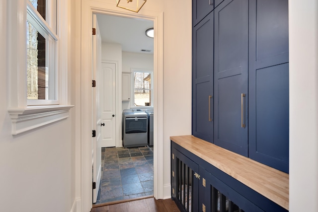 interior space featuring stone finish floor, washing machine and clothes dryer, and visible vents