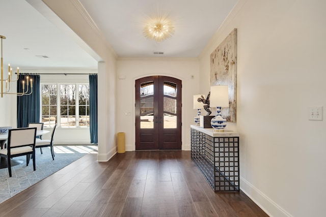 entryway featuring visible vents, arched walkways, dark wood finished floors, french doors, and a notable chandelier