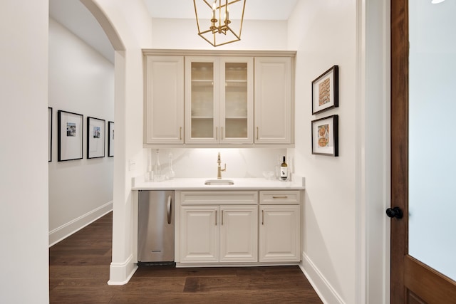 bar featuring arched walkways, dark wood-style flooring, refrigerator, a sink, and baseboards