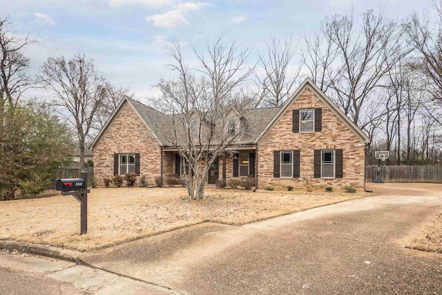 view of front of house featuring fence and brick siding