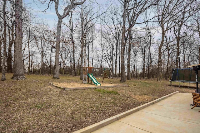 view of yard with playground community and a trampoline