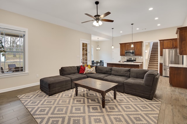 living area with light wood-style floors, recessed lighting, baseboards, and stairs