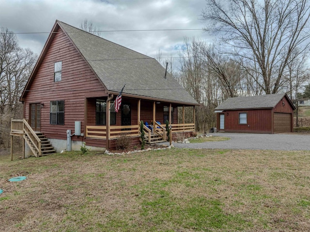 chalet / cabin with an outbuilding, a detached garage, a porch, a shingled roof, and a front lawn