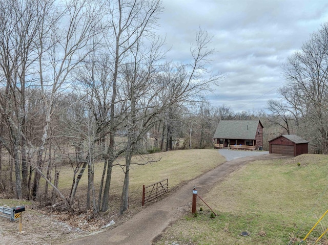 view of yard with a detached garage, fence, and an outbuilding