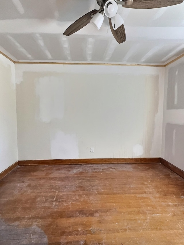 empty room with ornamental molding, baseboards, and hardwood / wood-style floors