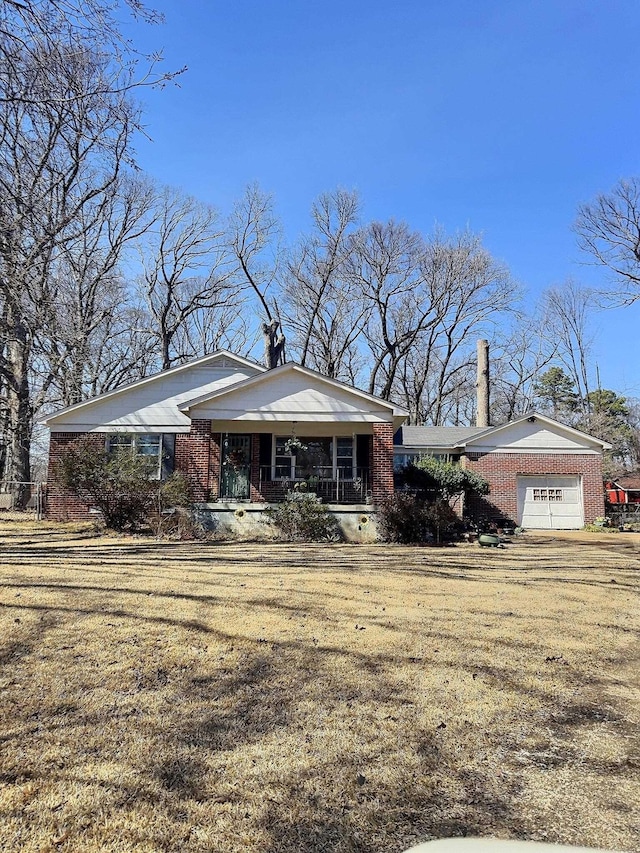 view of front of property featuring an attached garage, covered porch, and brick siding