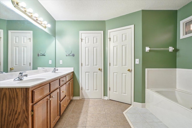 full bath featuring a garden tub, double vanity, a sink, a textured ceiling, and tile patterned floors