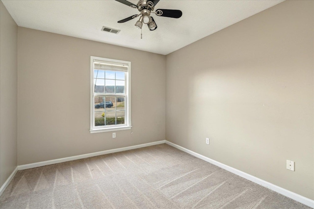 empty room featuring a ceiling fan, carpet flooring, visible vents, and baseboards