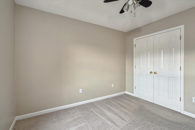 unfurnished bedroom featuring a ceiling fan, a closet, baseboards, and carpet flooring