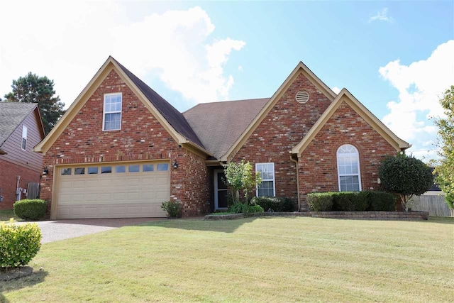 traditional-style house featuring a garage, driveway, a front lawn, and brick siding