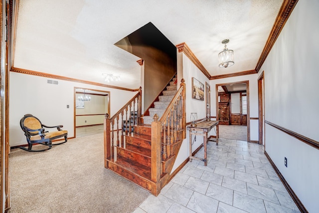 stairs with visible vents, a notable chandelier, a textured ceiling, crown molding, and carpet flooring