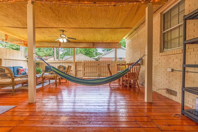 view of jungle gym featuring a deck, ceiling fan, and fence