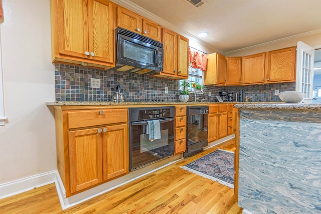 kitchen featuring black appliances, light wood finished floors, backsplash, and crown molding