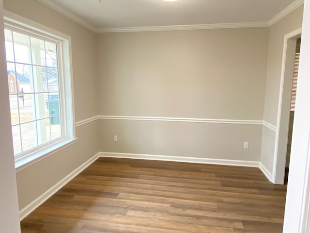 empty room with crown molding, plenty of natural light, baseboards, and wood finished floors