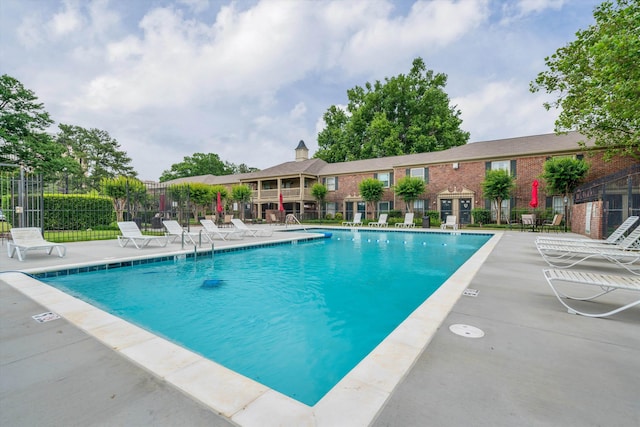 community pool featuring a patio area and fence