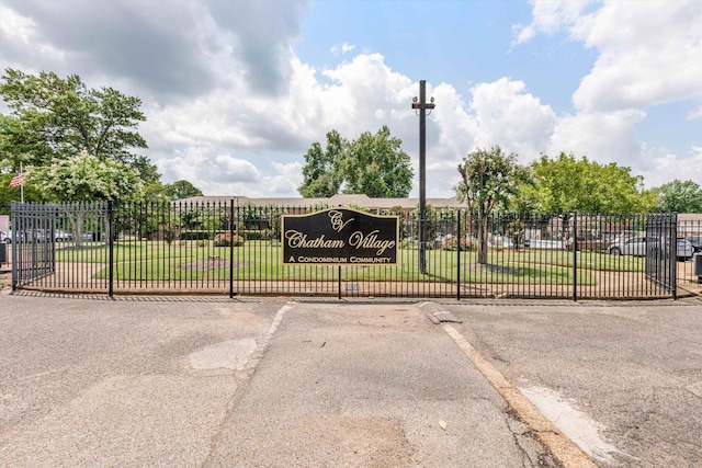 view of gate with a lawn and fence