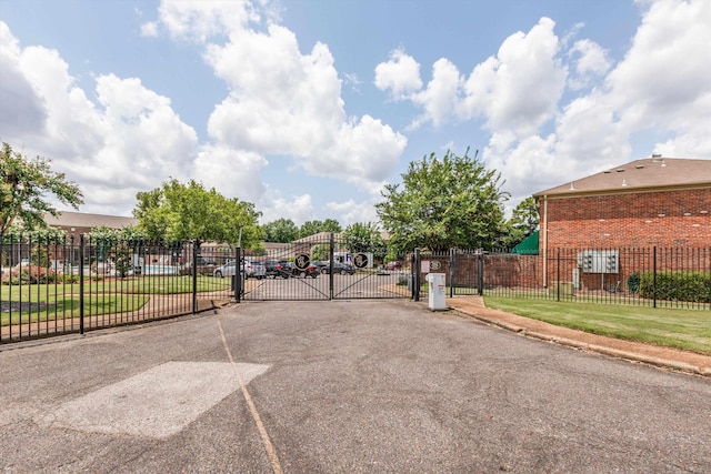 exterior space featuring a gate, a gated entry, and curbs