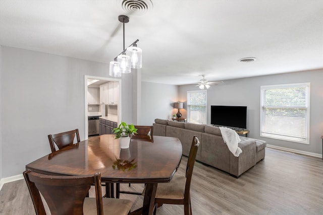 dining space with light wood-style floors, visible vents, and plenty of natural light