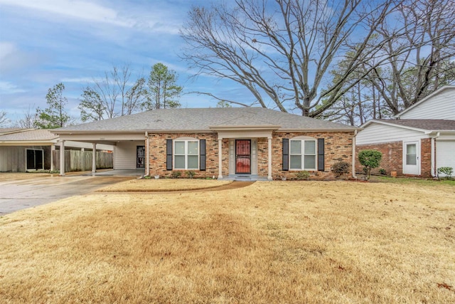 ranch-style home with concrete driveway, a carport, a front lawn, and brick siding