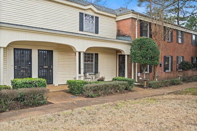 view of front facade with covered porch and brick siding