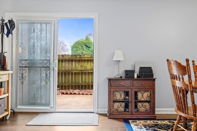 doorway to outside with wood finished floors and baseboards