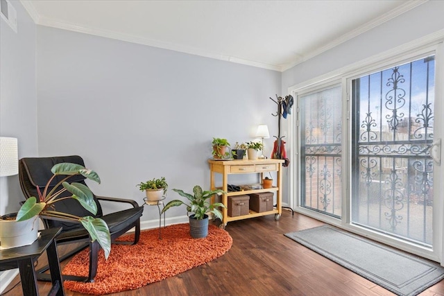 living area featuring baseboards, wood finished floors, and crown molding