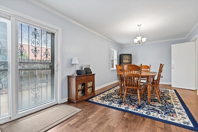 dining room featuring a chandelier, ornamental molding, wood finished floors, and baseboards