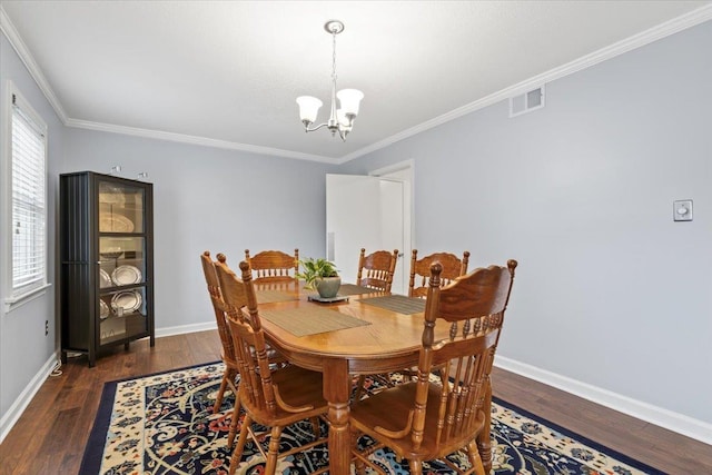 dining area with crown molding, visible vents, wood finished floors, a chandelier, and baseboards