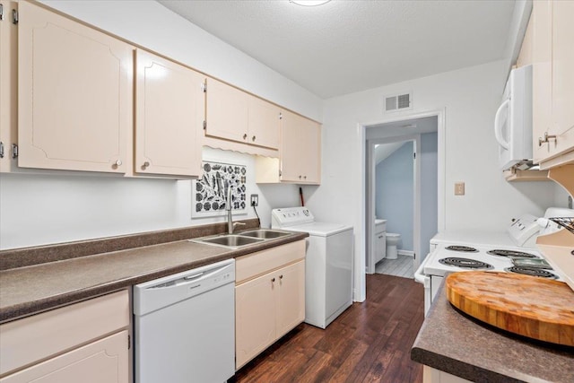 kitchen with dark countertops, visible vents, dark wood-type flooring, washer / dryer, and white appliances