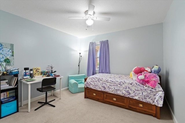 bedroom featuring light colored carpet, ceiling fan, a textured ceiling, and baseboards