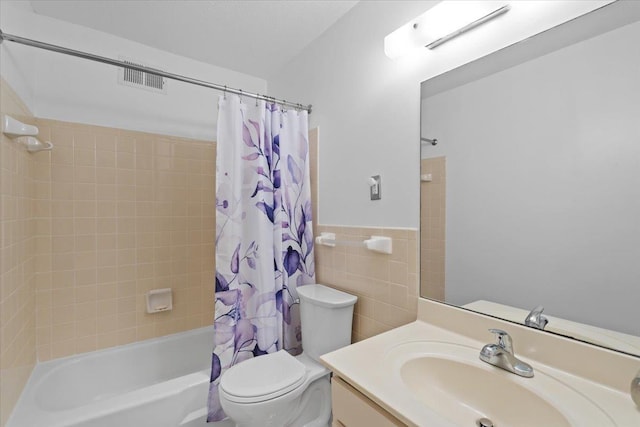 full bath with toilet, visible vents, vanity, tile walls, and shower / bath combination with curtain