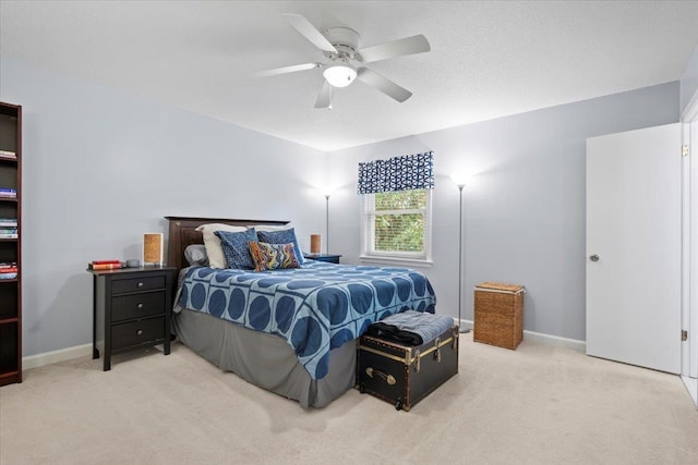 bedroom featuring light carpet, ceiling fan, and baseboards