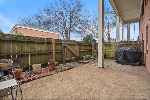 view of patio / terrace with area for grilling, a fenced backyard, and a gate