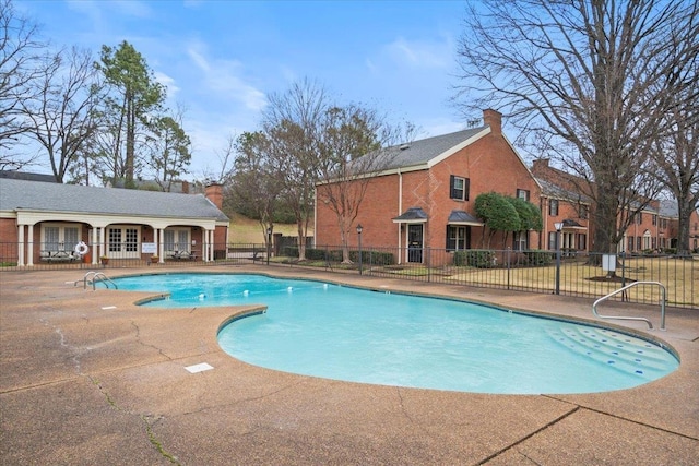 pool with a patio, french doors, and fence