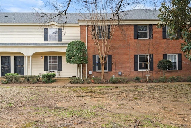 view of front of house with a porch and brick siding