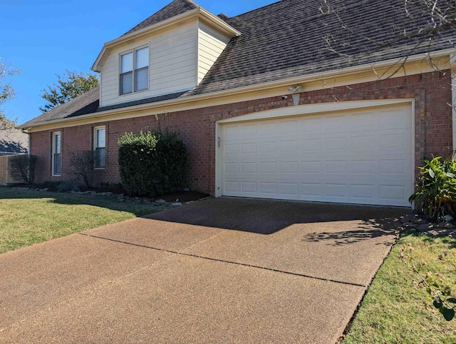 view of front of property featuring a shingled roof, a front yard, concrete driveway, and brick siding