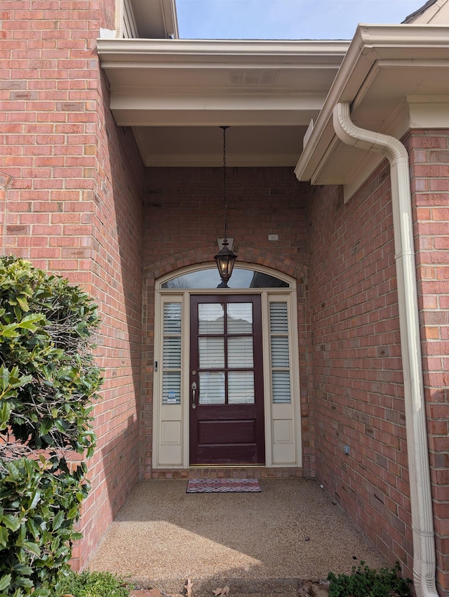 view of exterior entry with brick siding